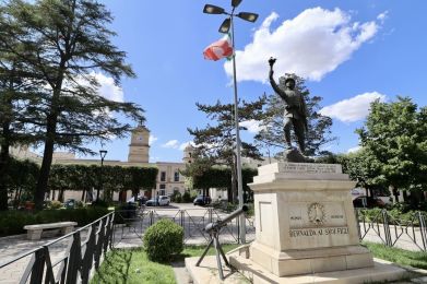 una statua di un uomo con una bandiera su un piedistallo