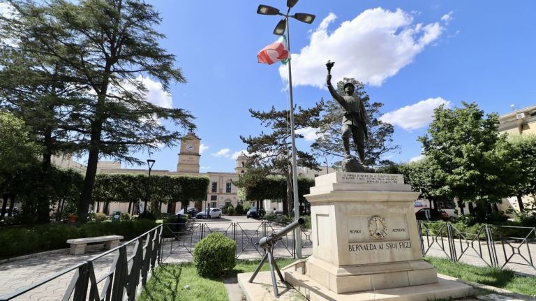 una statua di un uomo con una bandiera su un piedistallo