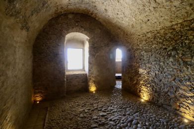 una stanza in pietra con finestre ad arco e pavimento in pietra