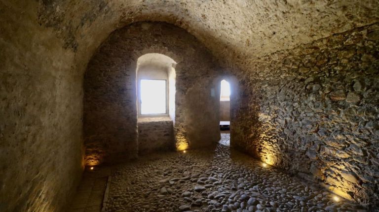 una stanza in pietra con finestre ad arco e pavimento in pietra