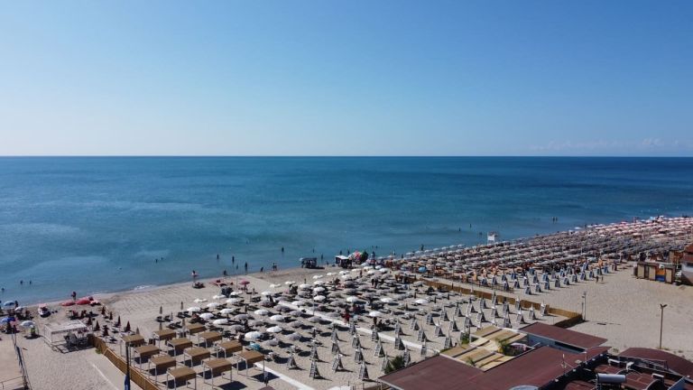 una spiaggia con ombrelloni e sedie