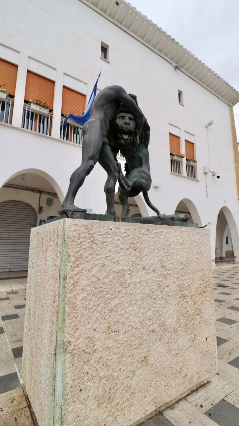 una statua di un uomo con un leone su un piedistallo di pietra