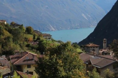 un gruppo di case su una collina vicino a uno specchio d'acqua