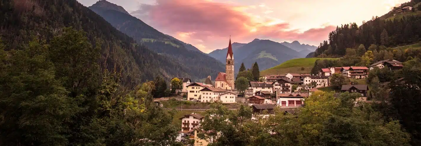 una città con un campanile e le montagne sullo sfondo