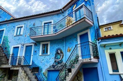 un edificio blu con un murales sul lato
