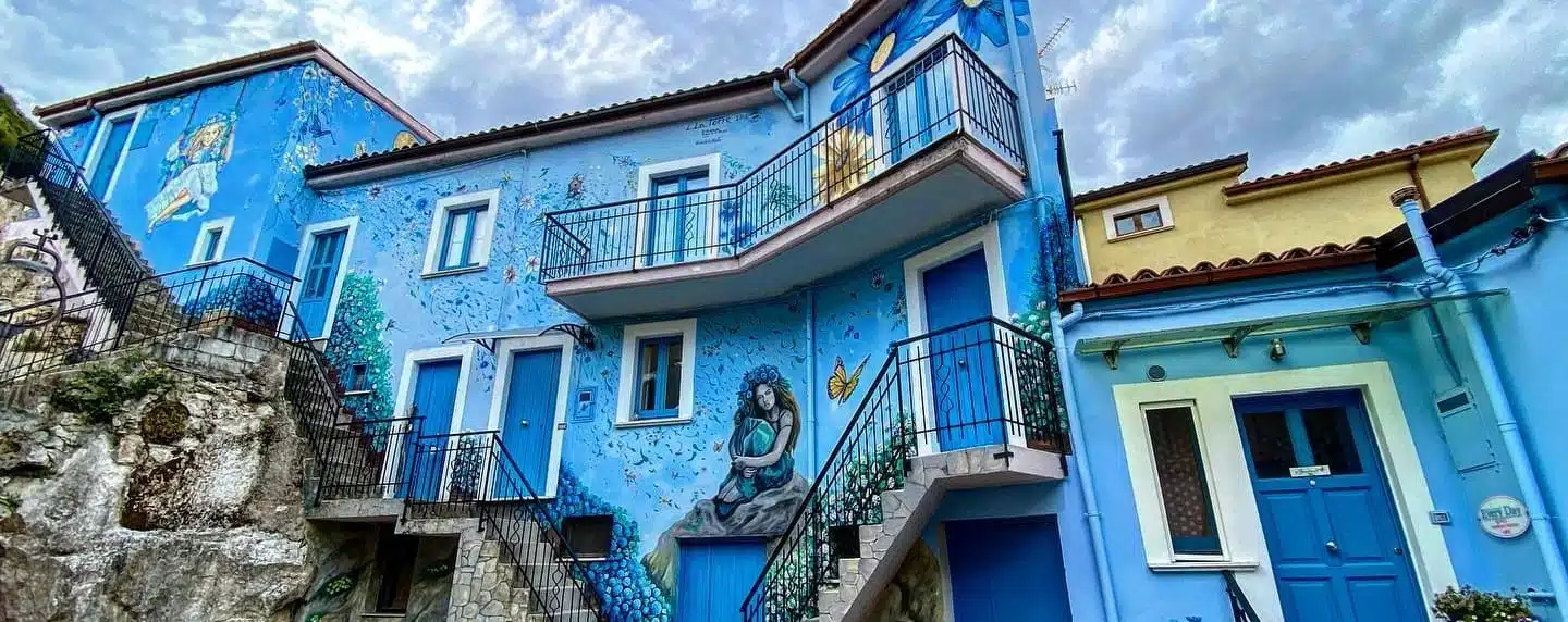 un edificio blu con un murales sul lato