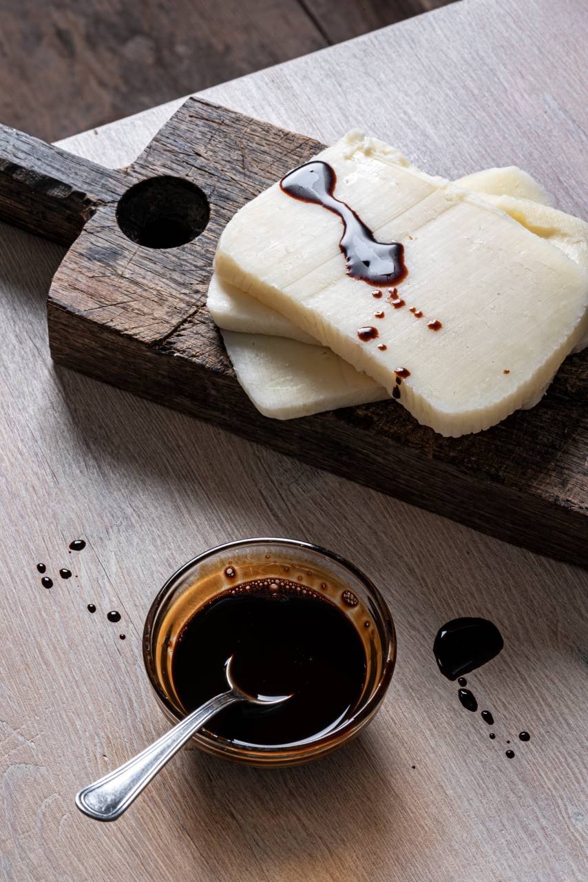 A wooden board with food next to a spoon