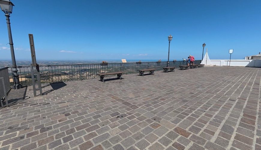 coppia di persone in piazza con vista mare
