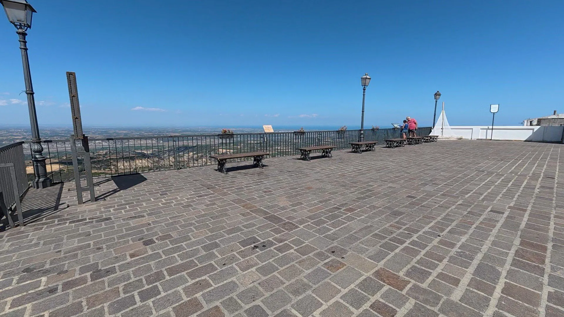 coppia di persone in piazza con vista mare